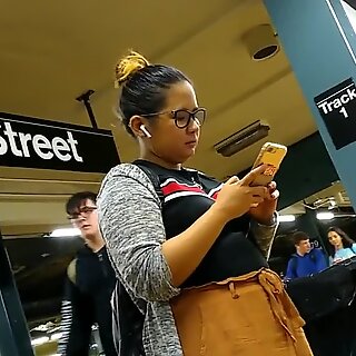 Слатка буцмасте филипина девојка са наочарама чека воз